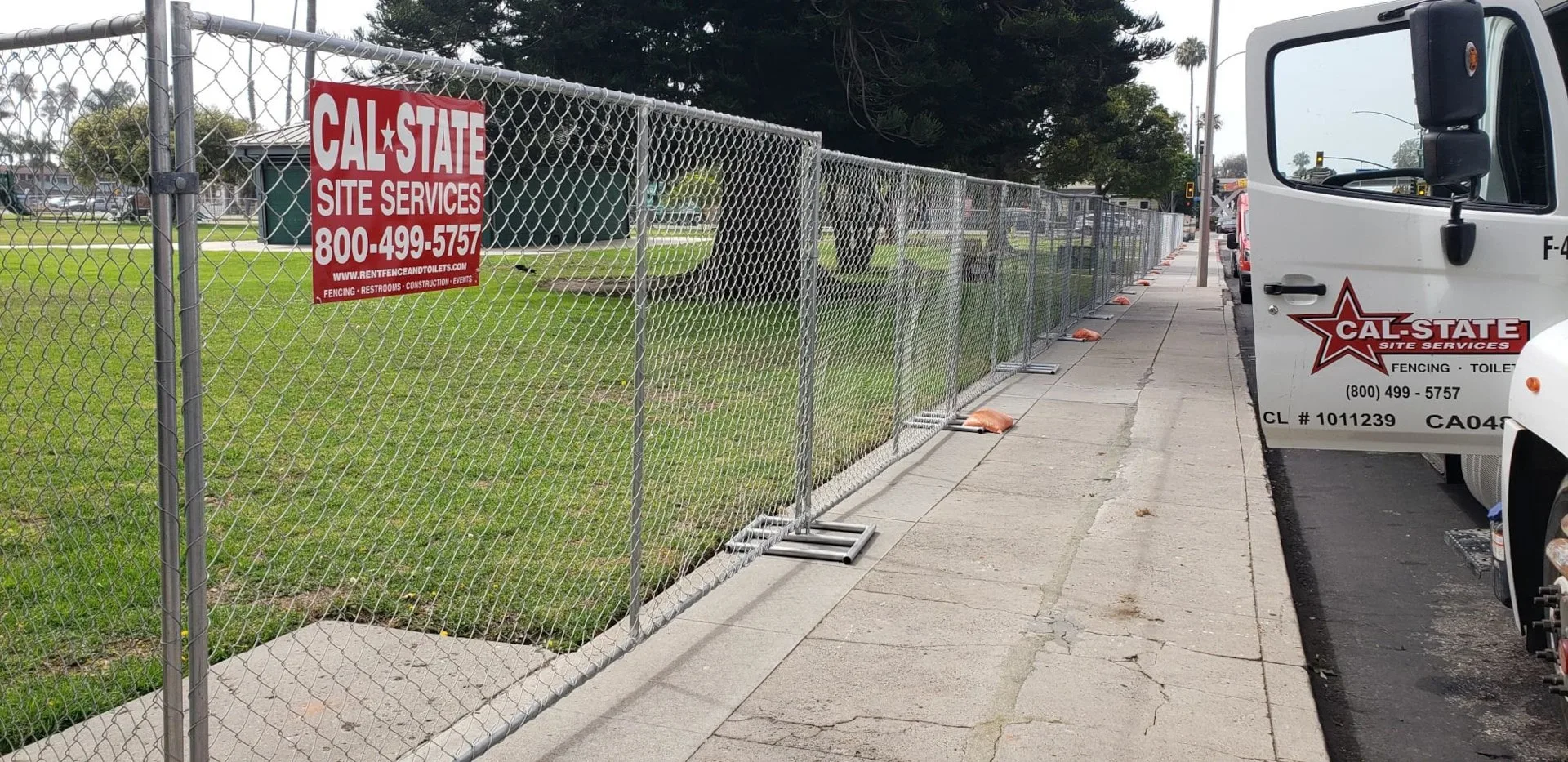Cal-State Site Service truck with open door parked next to fence